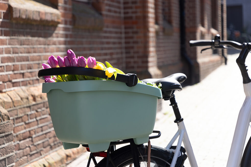 Clipper fietsmand met bloemen achter op de fiets
